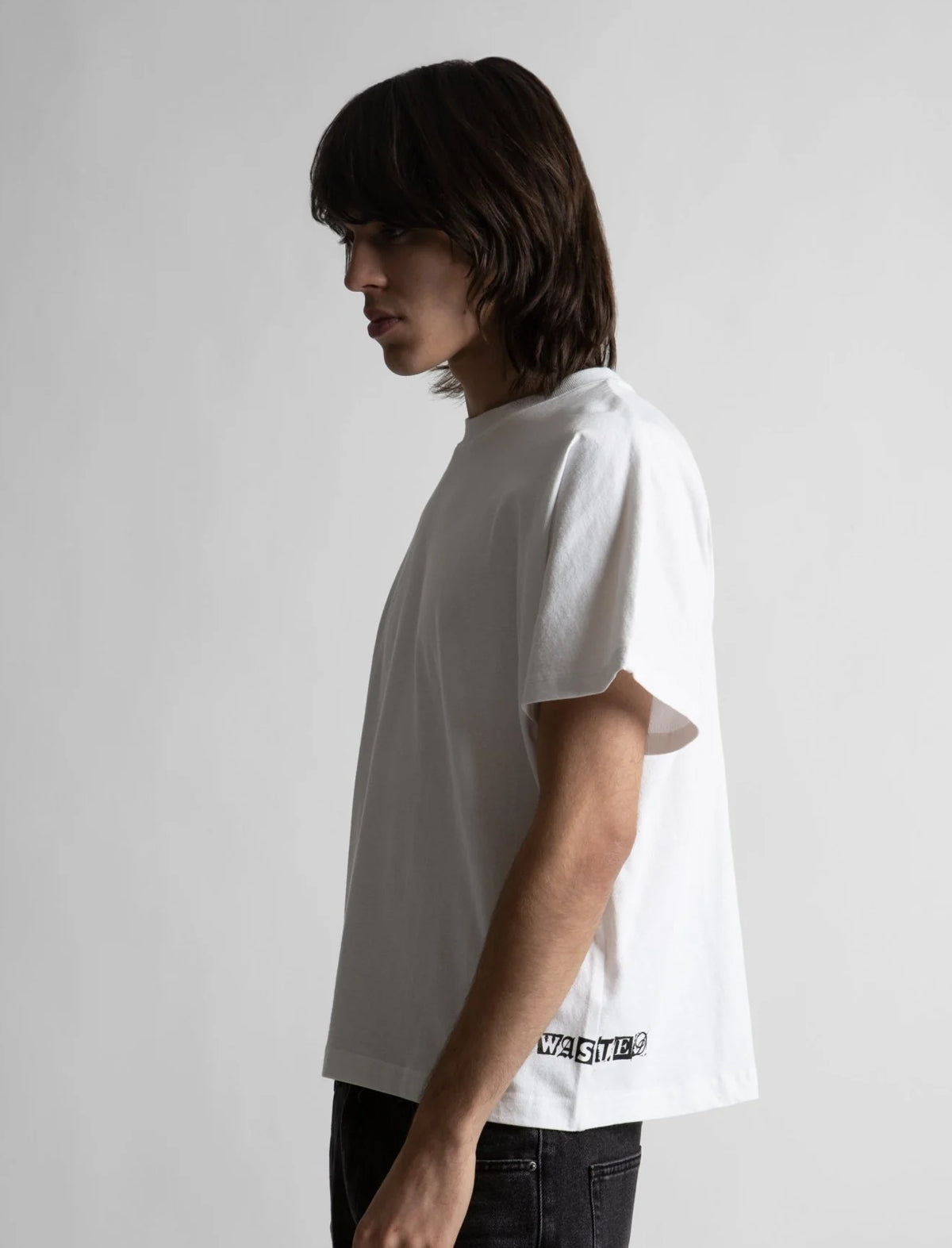 Person wearing a white t-shirt with text on a plain background