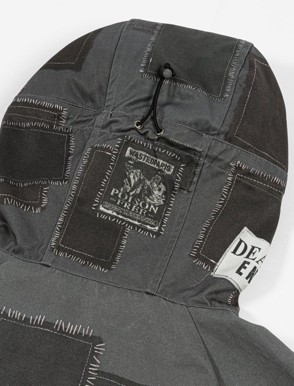 Close-up of a dark gray jacket with brand labels on a white background