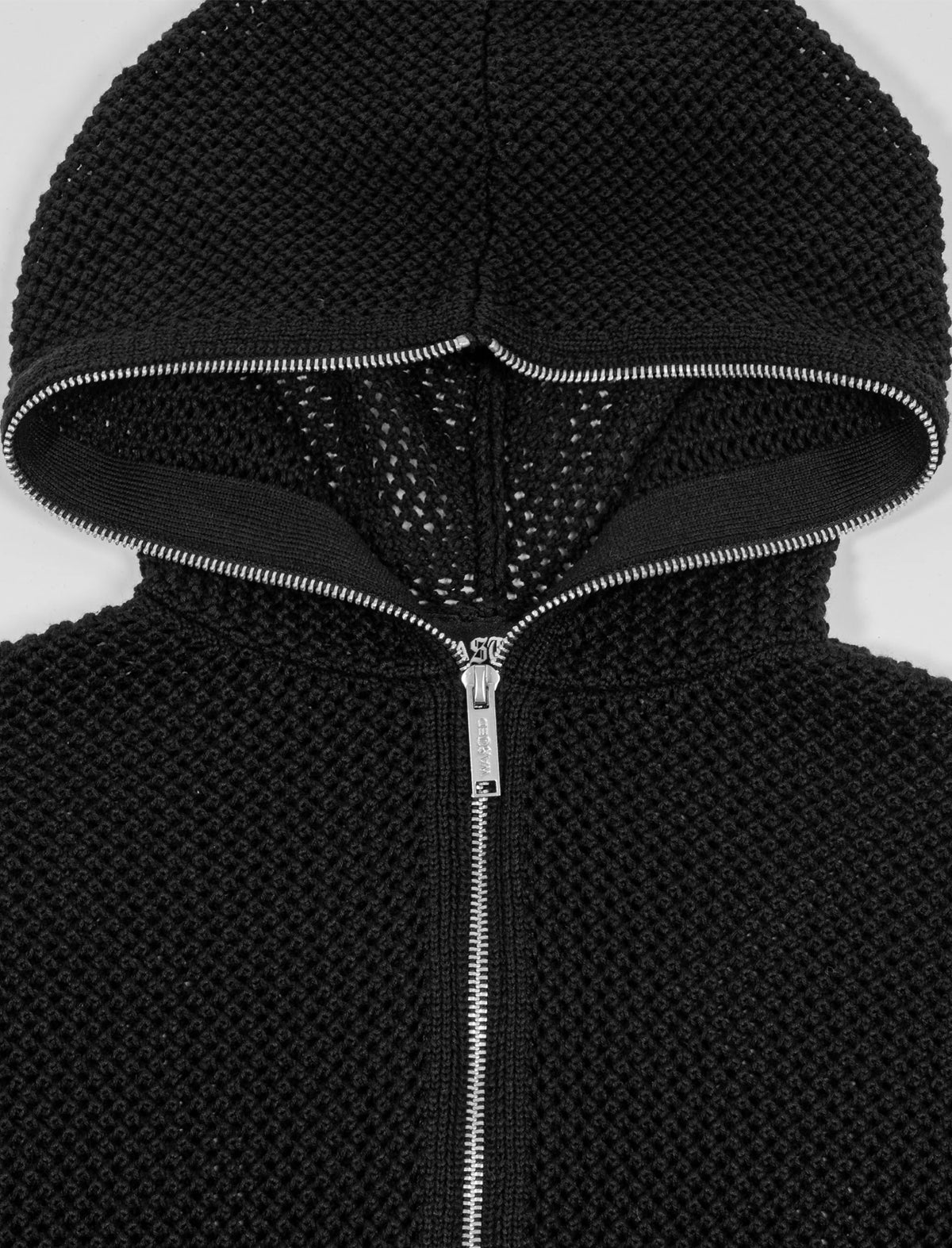 Close-up of a black textured hoodie with a zipper on a white background