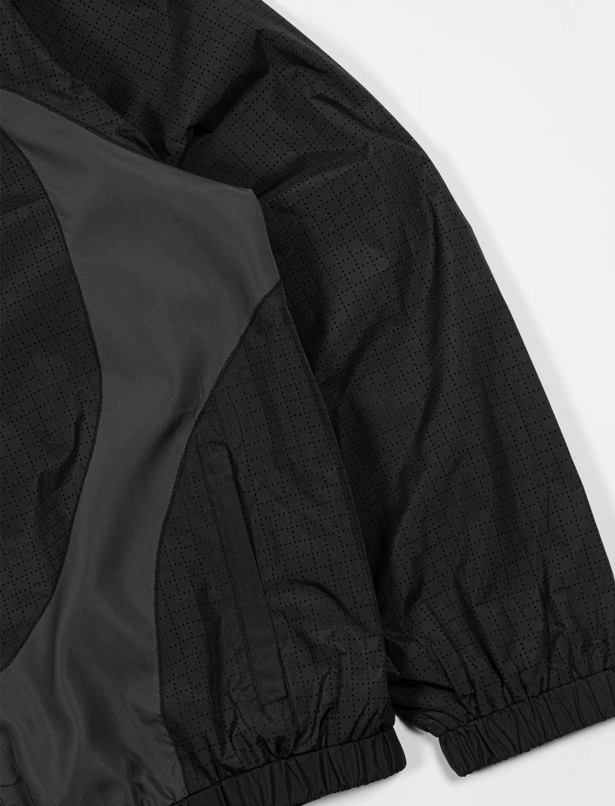Close-up of a black jacket with a textured pattern on a white background