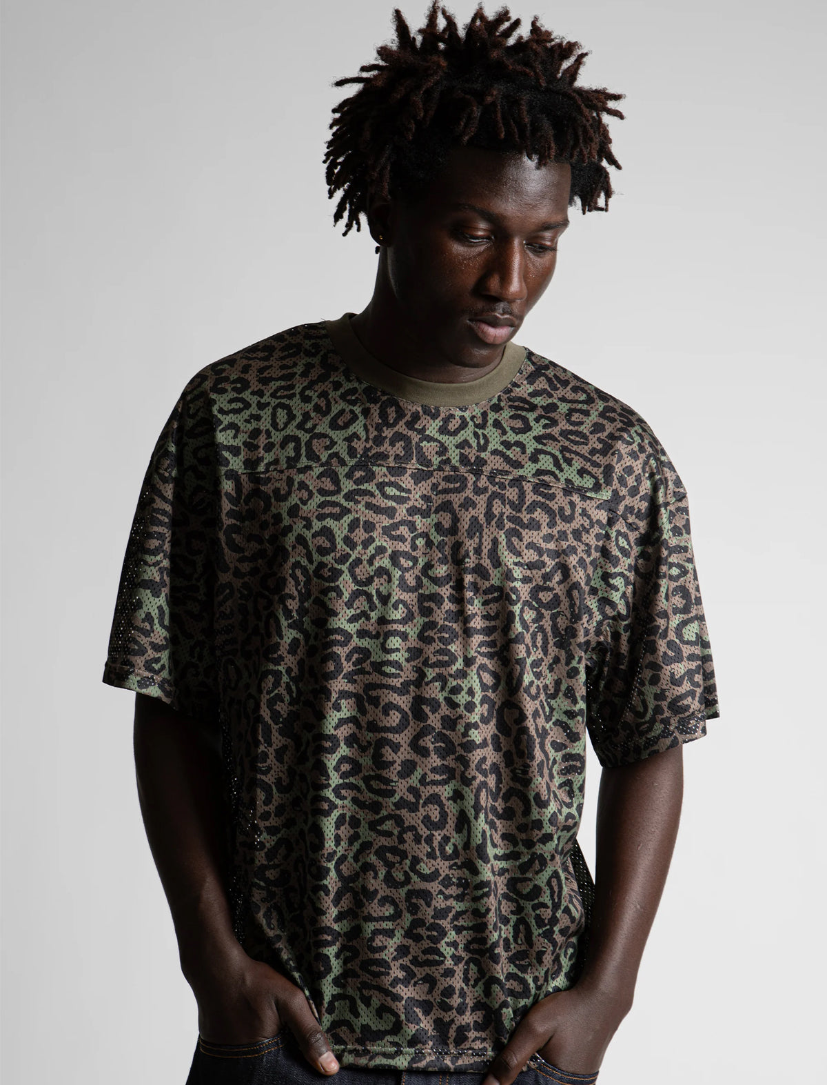 Person wearing a leopard print t-shirt against a plain background