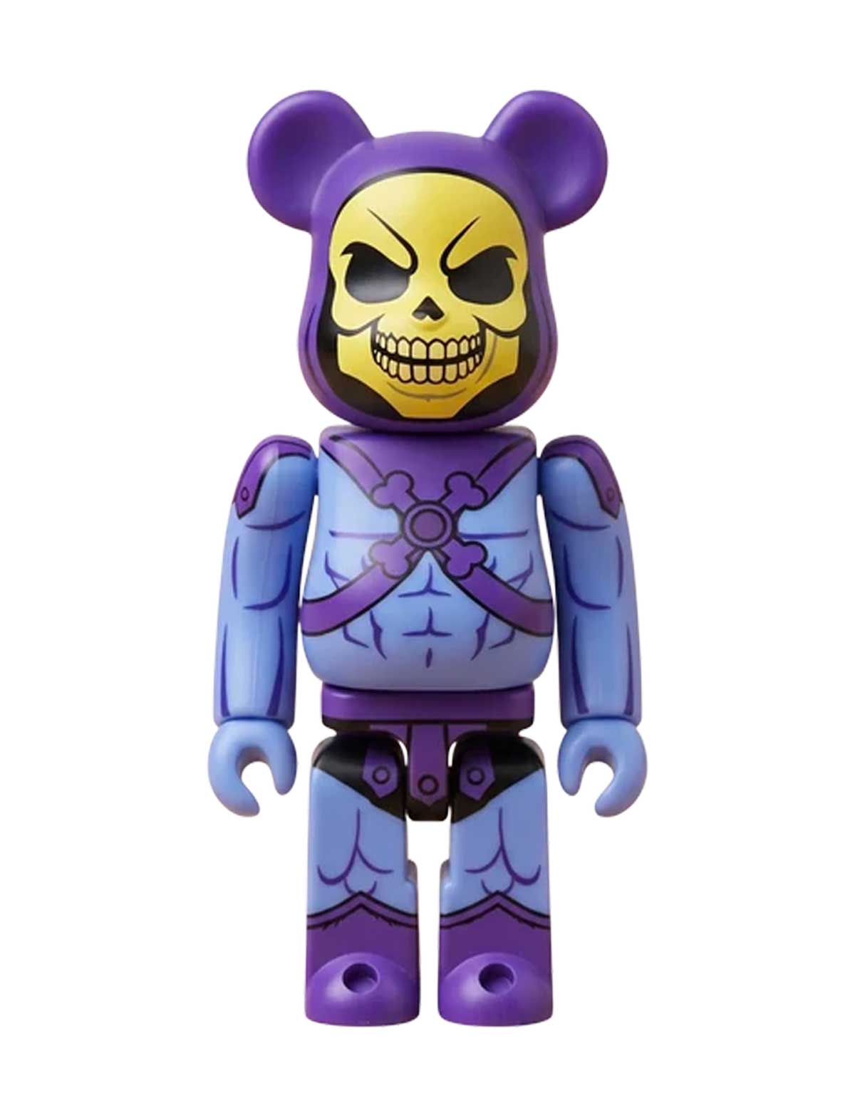 A collectible bearbrick-style toy figure of Skeletor from Lego Friends, featuring a purple bear head with a skull face and a blue-purple armored body, isolated on a white background.
