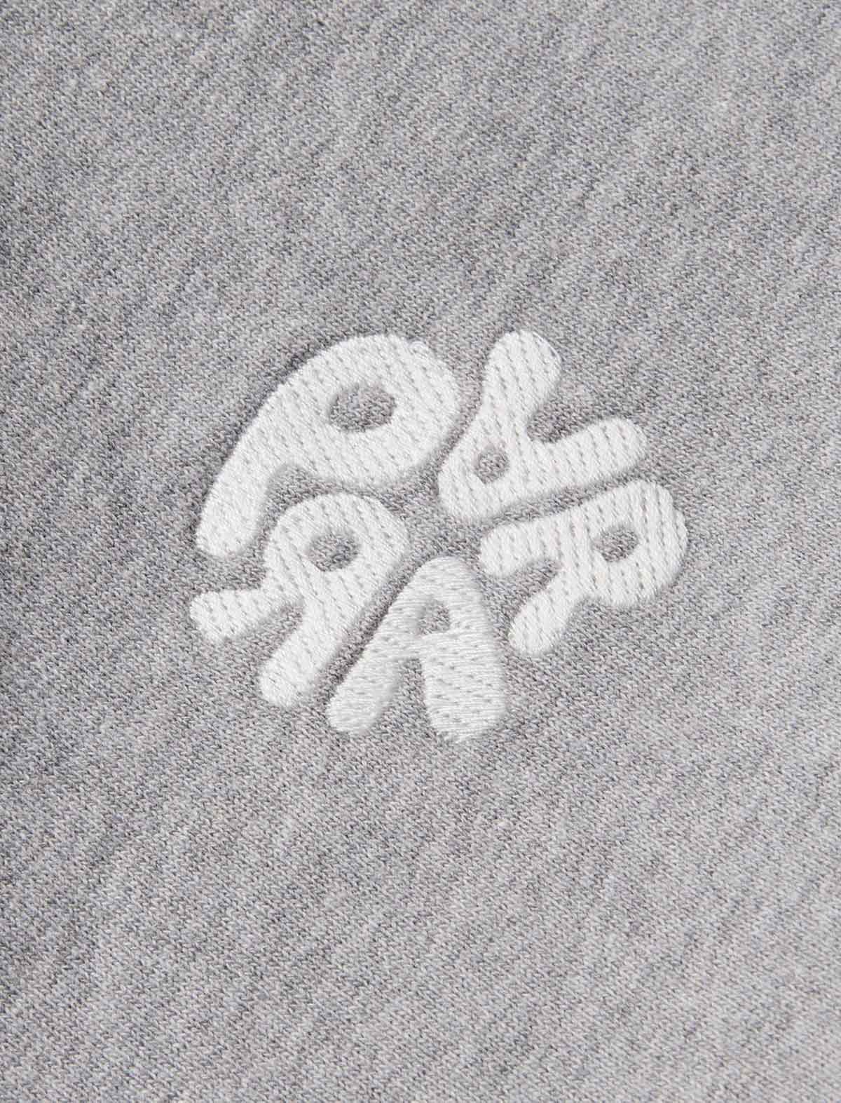 Close-up of a white embroidered Parra logo on a heather gray fabric background.