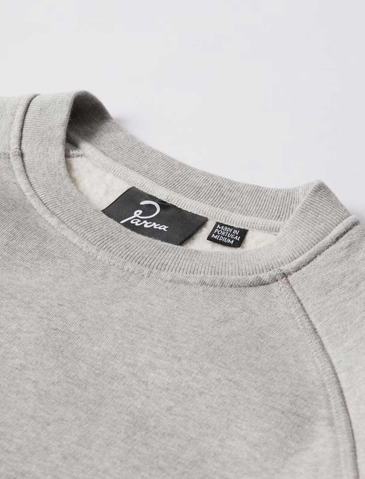 Close-up of a gray sweatshirt with 'farra' brand label on a light gray background