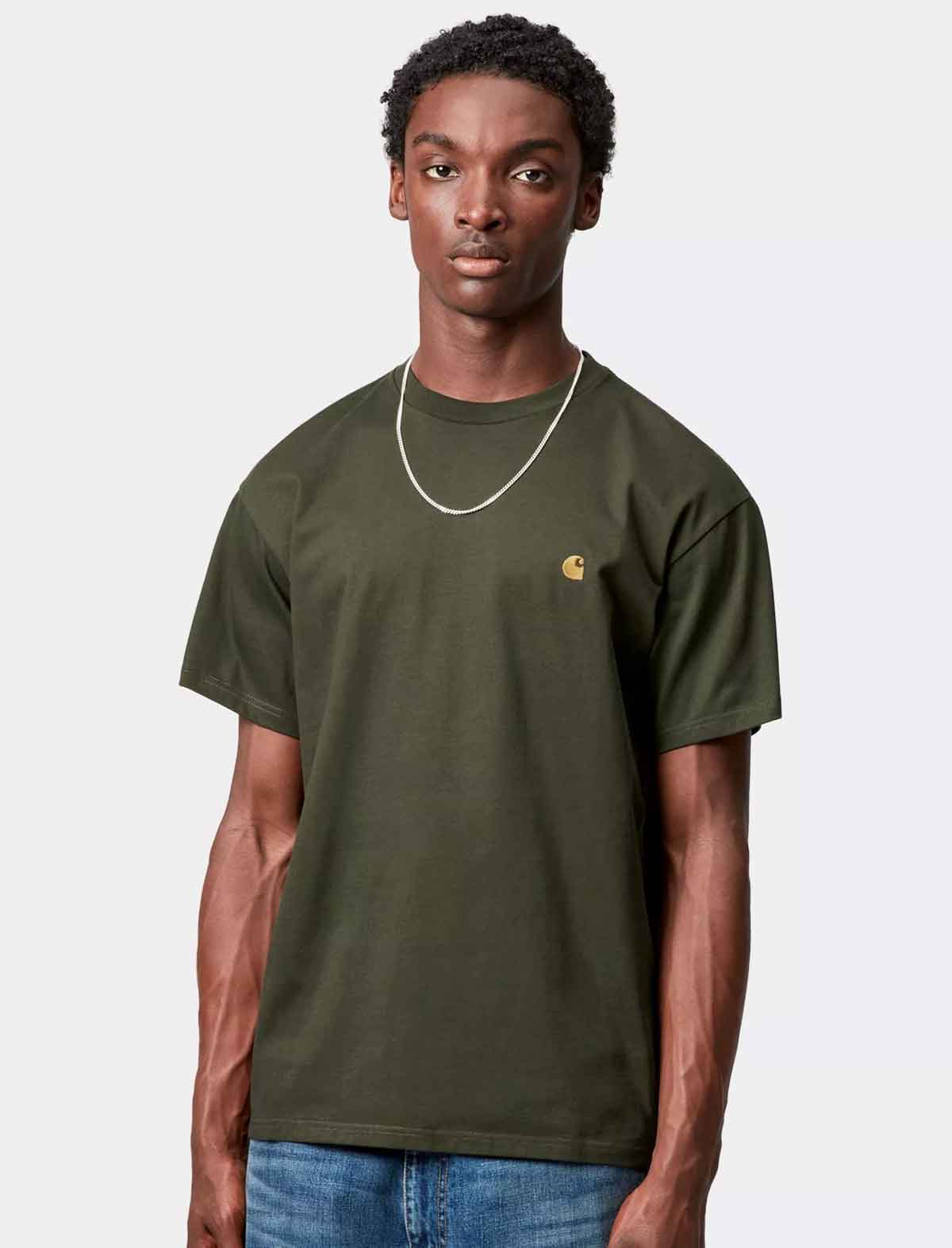 Man wearing a carhartt green t-shirt with a brand logo on a white background