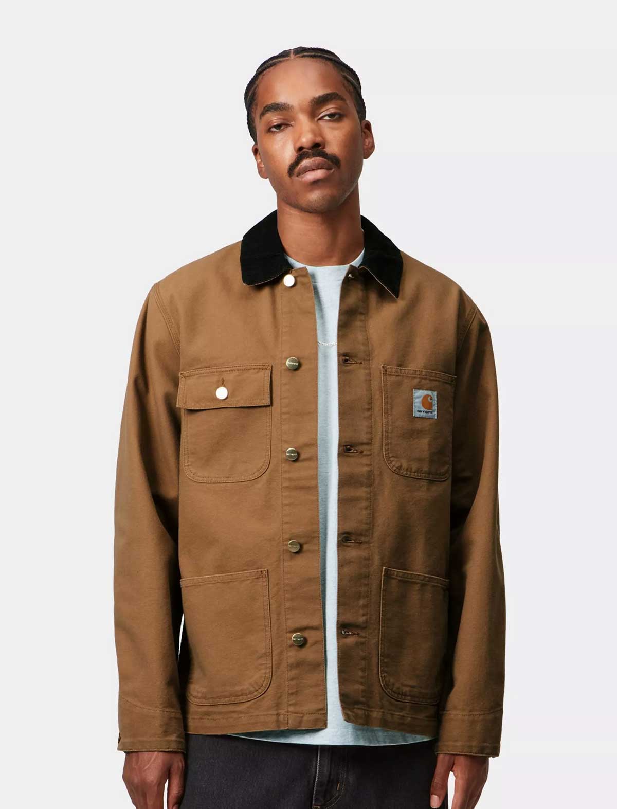 Man wearing a Carhartt brown jacket with a visible brand logo on a white background