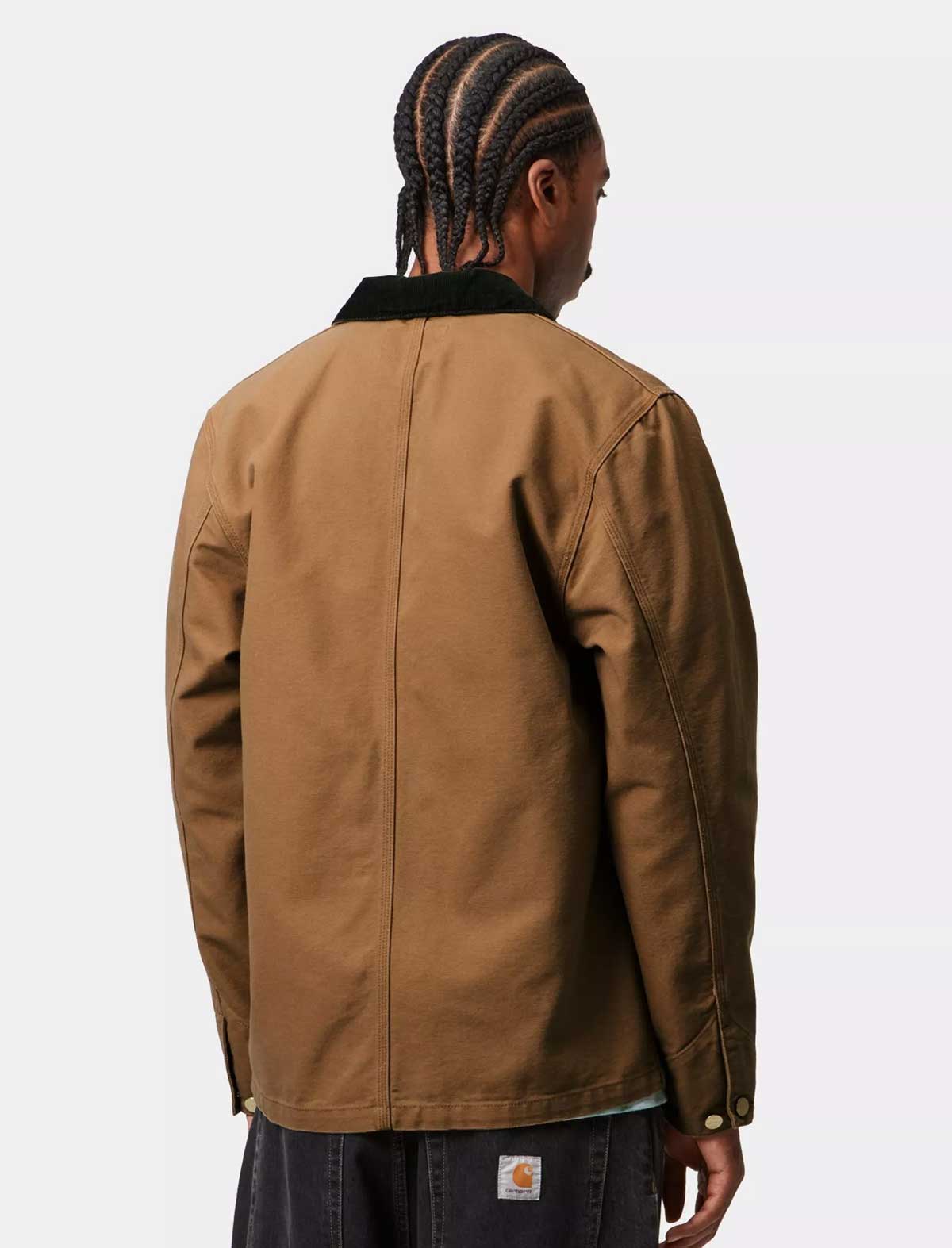 Person wearing a Carhartt brown jacket on a white background