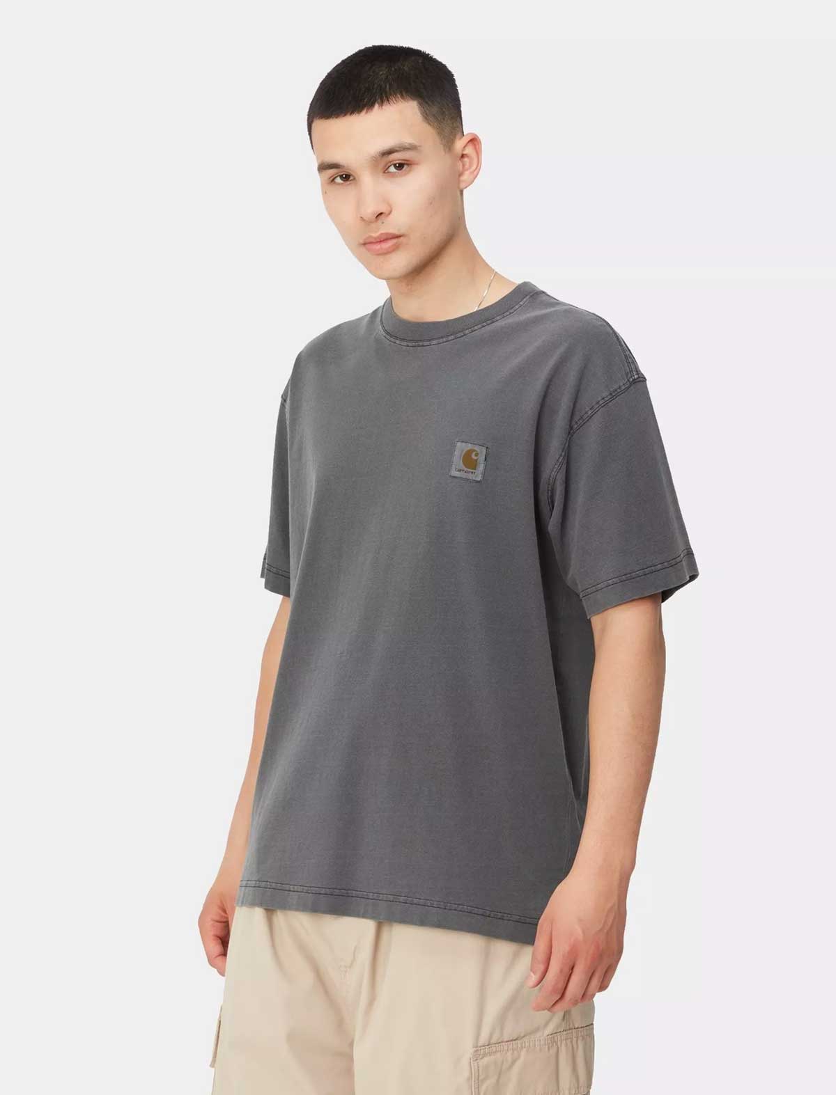 Person wearing a carhartt wip nelson gray t-shirt with a brand logo on a white background