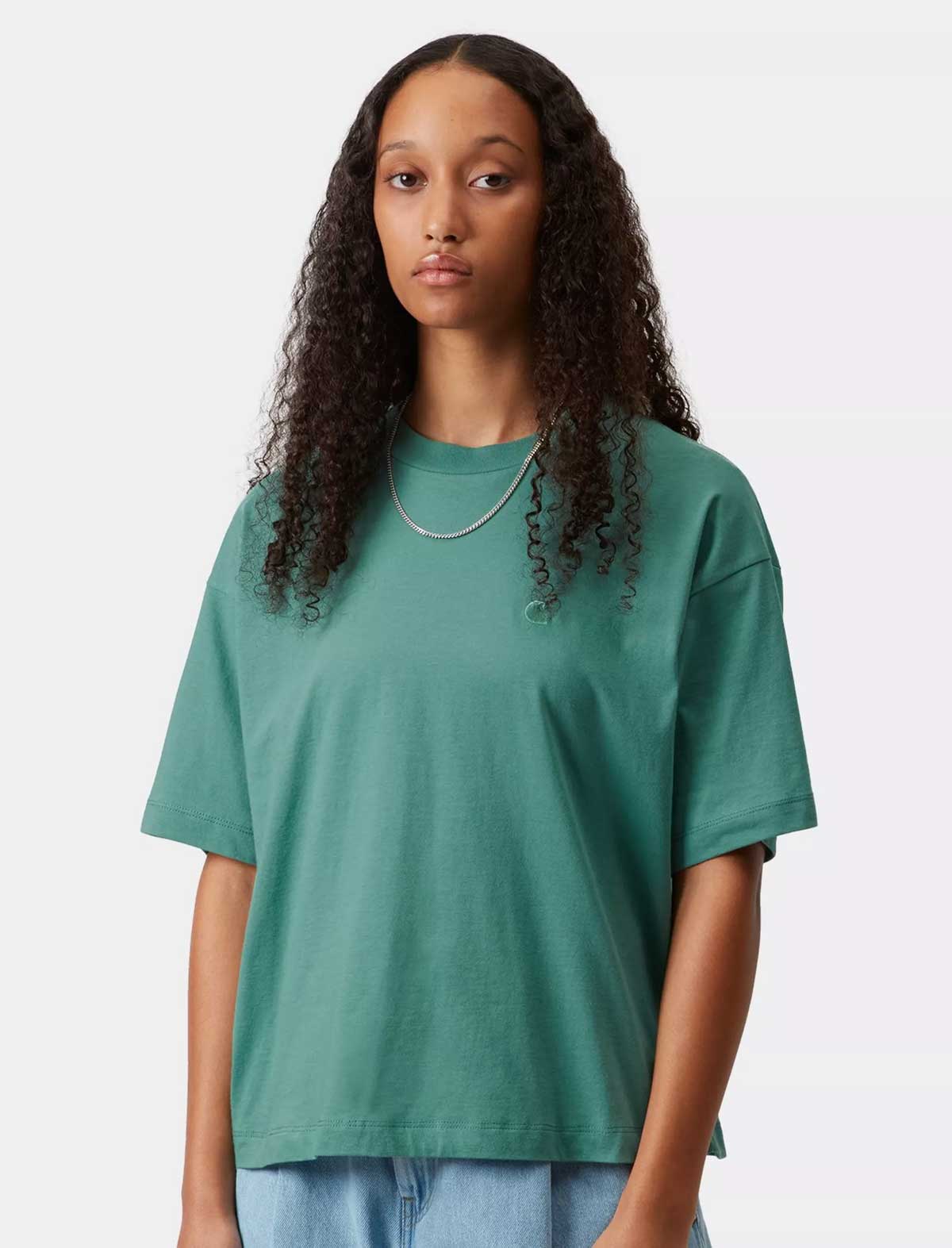 Woman wearing a Carhartt teal t-shirt against a white background