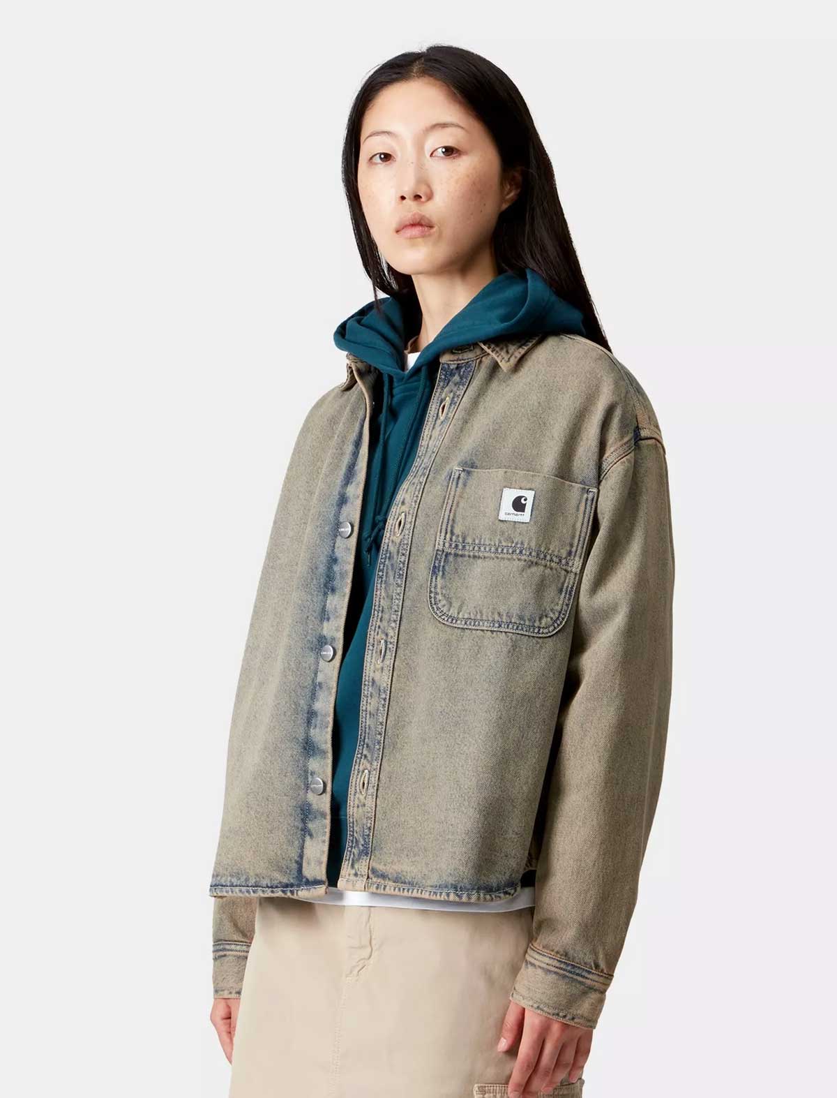 Person wearing a green jacket with a visible brand logo on a white background