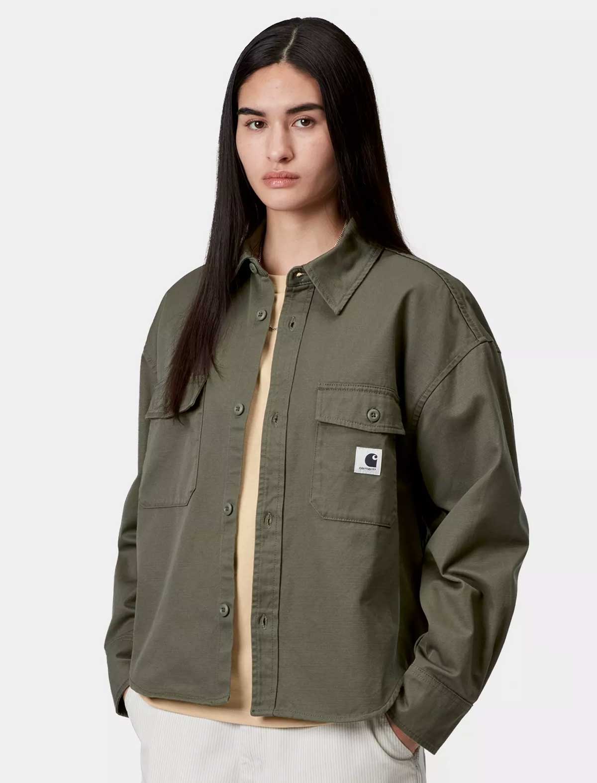 Person wearing a Carhartt WIP green jacket with a visible brand logo on a white background