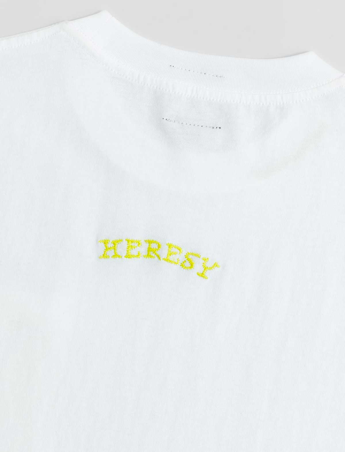 White t-shirt with 'HERESY' embroidered in yellow on a white background