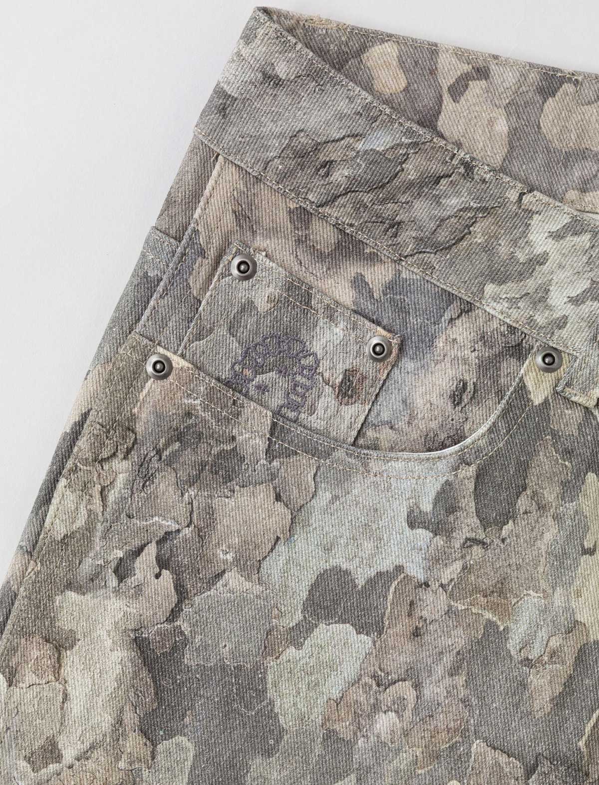 Camouflage-patterned fabric with stitching details on a white background