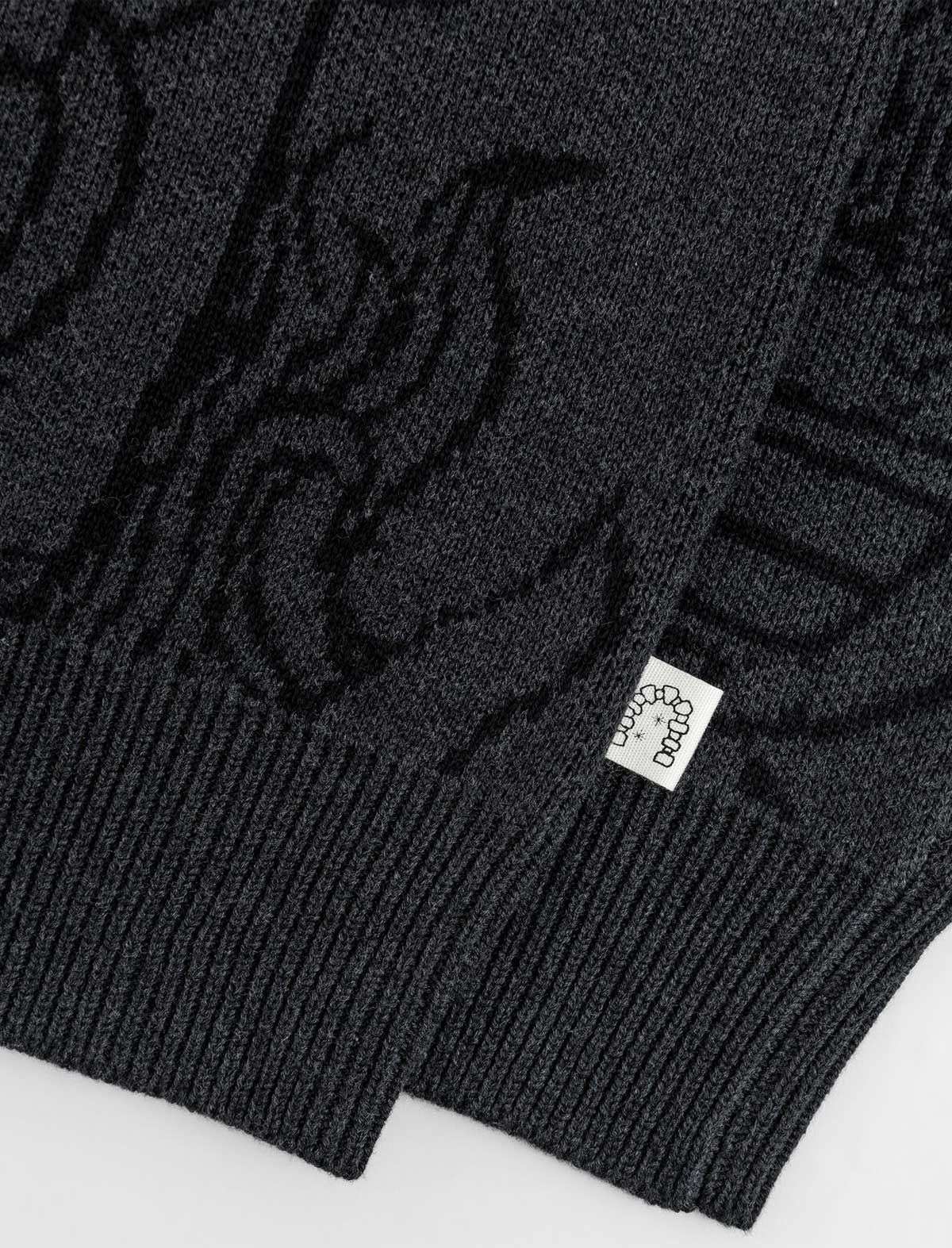 Heresy Dark gray sweater with a brand logo tag on a white background
