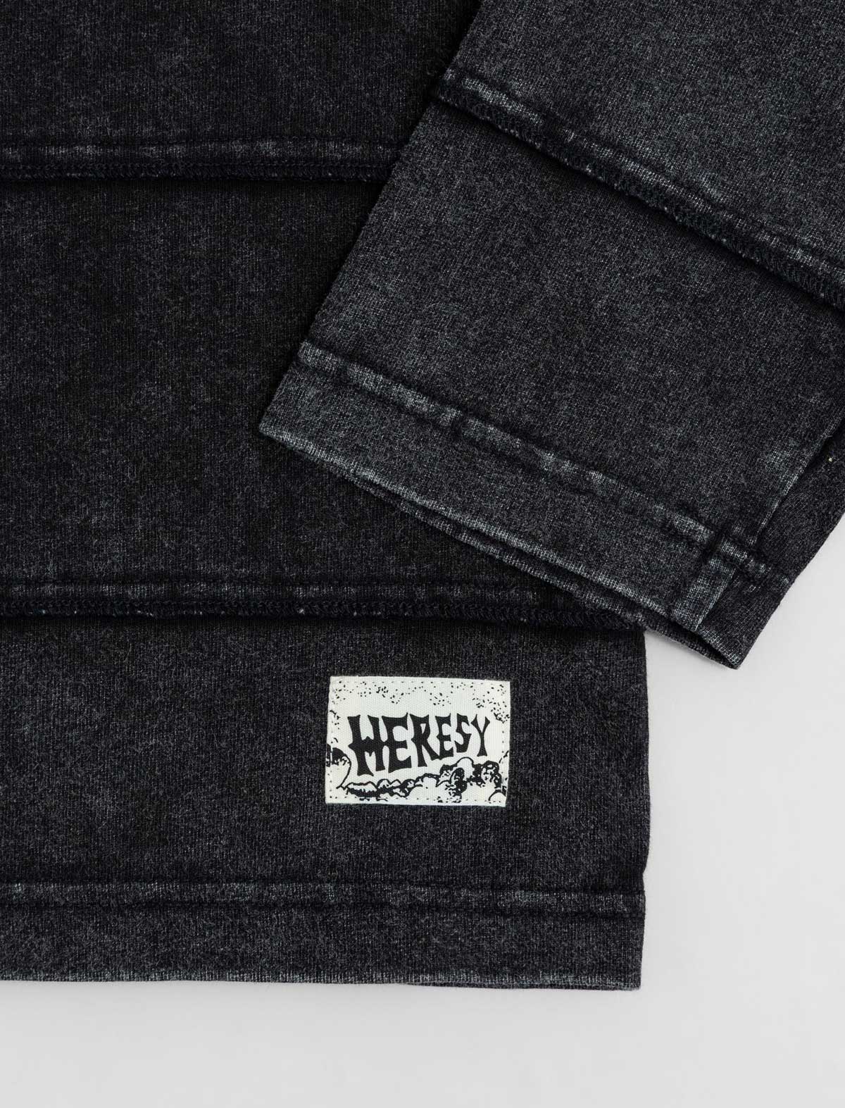 Black denim fabric with a visible brand label on a white background