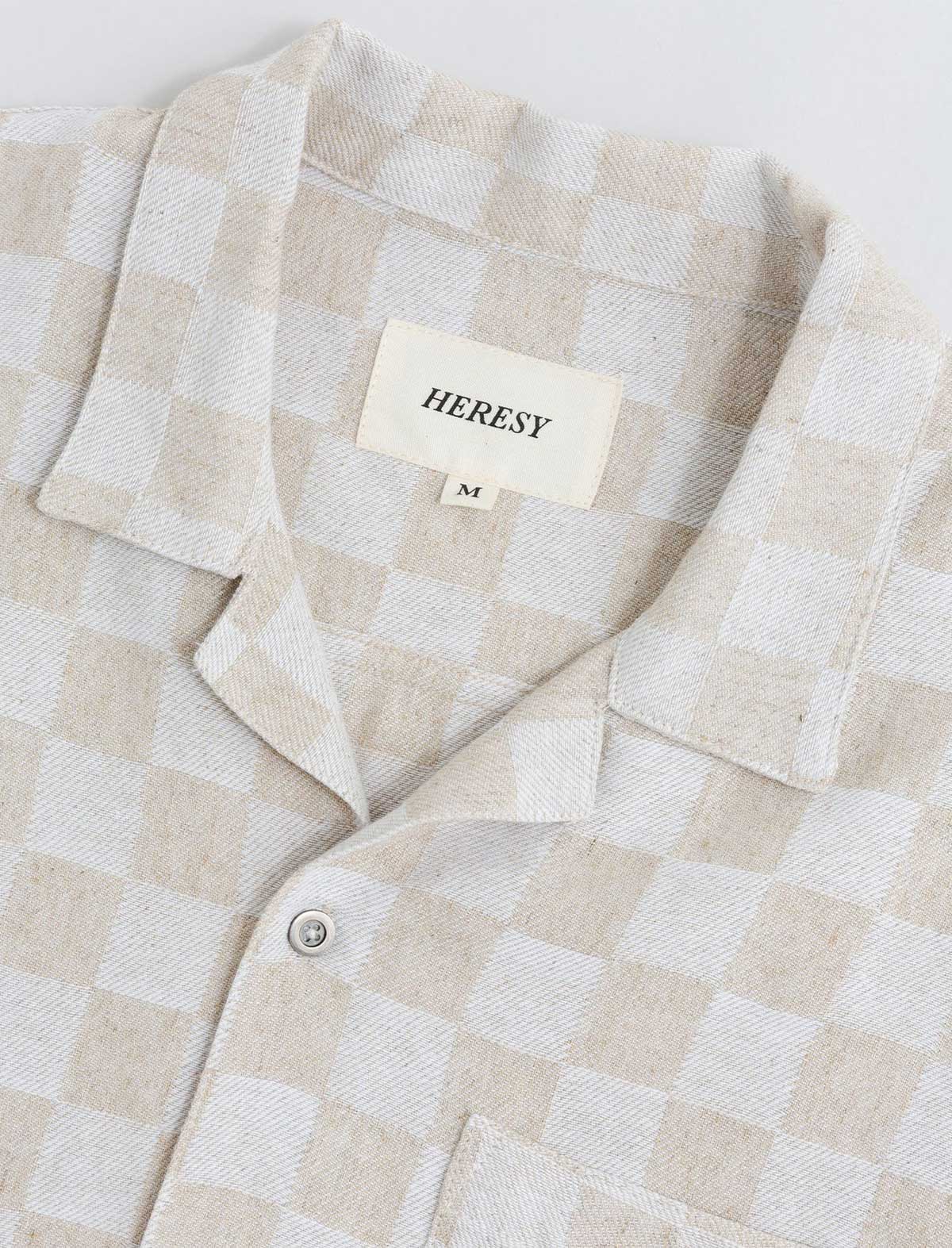 Beige and white checkered shirt with 'HERESY' label on a light gray background