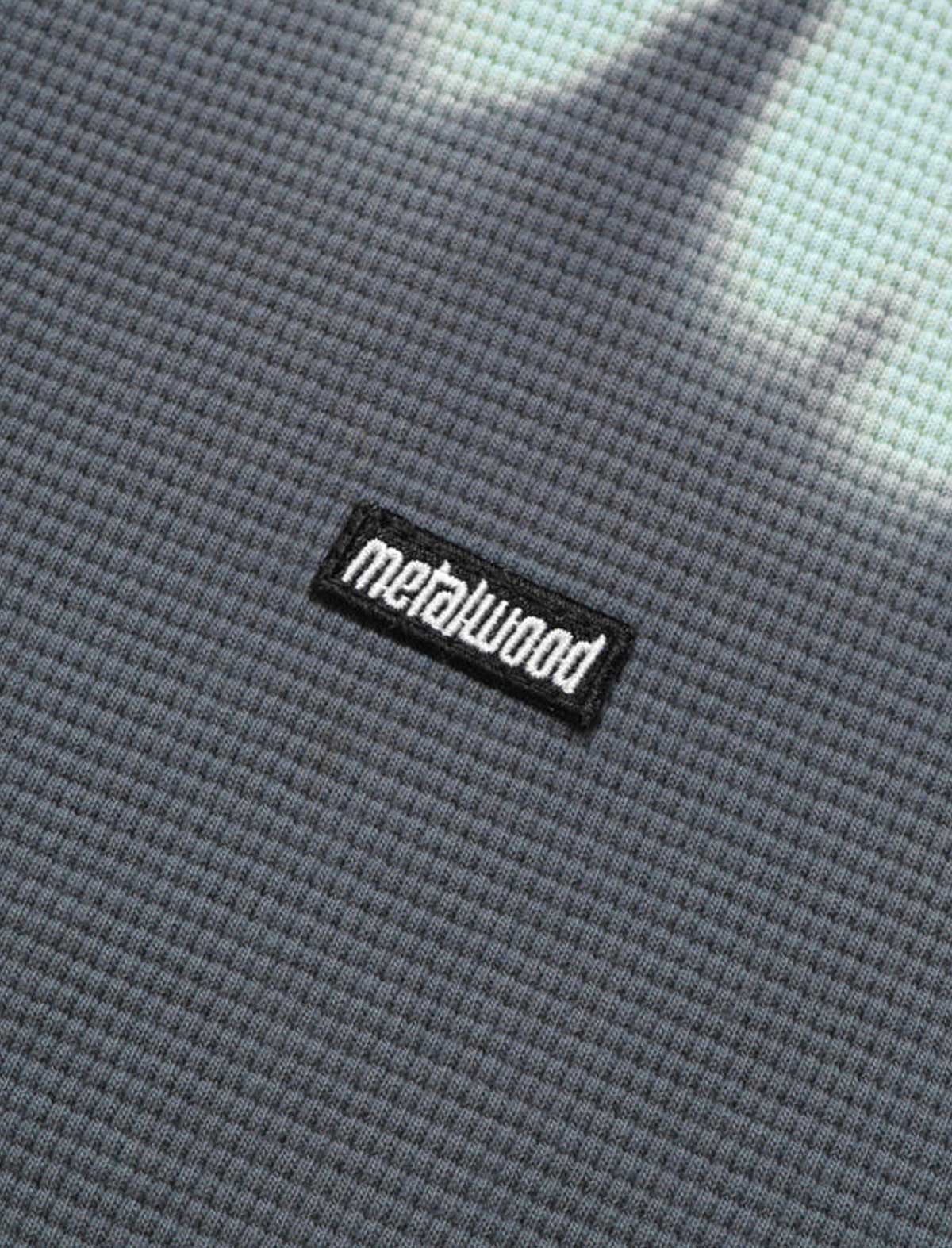 Close-up of a textured gray fabric with a 'metalwood' logo.