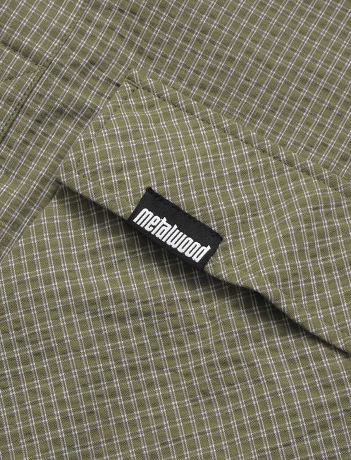 Close-up of a green checkered fabric with a 'metalwood' label.