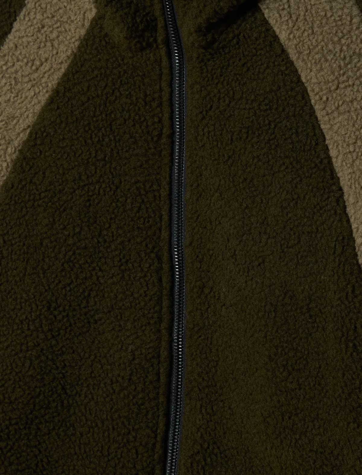 Close-up of a textured brown fabric with a zipper running vertically.