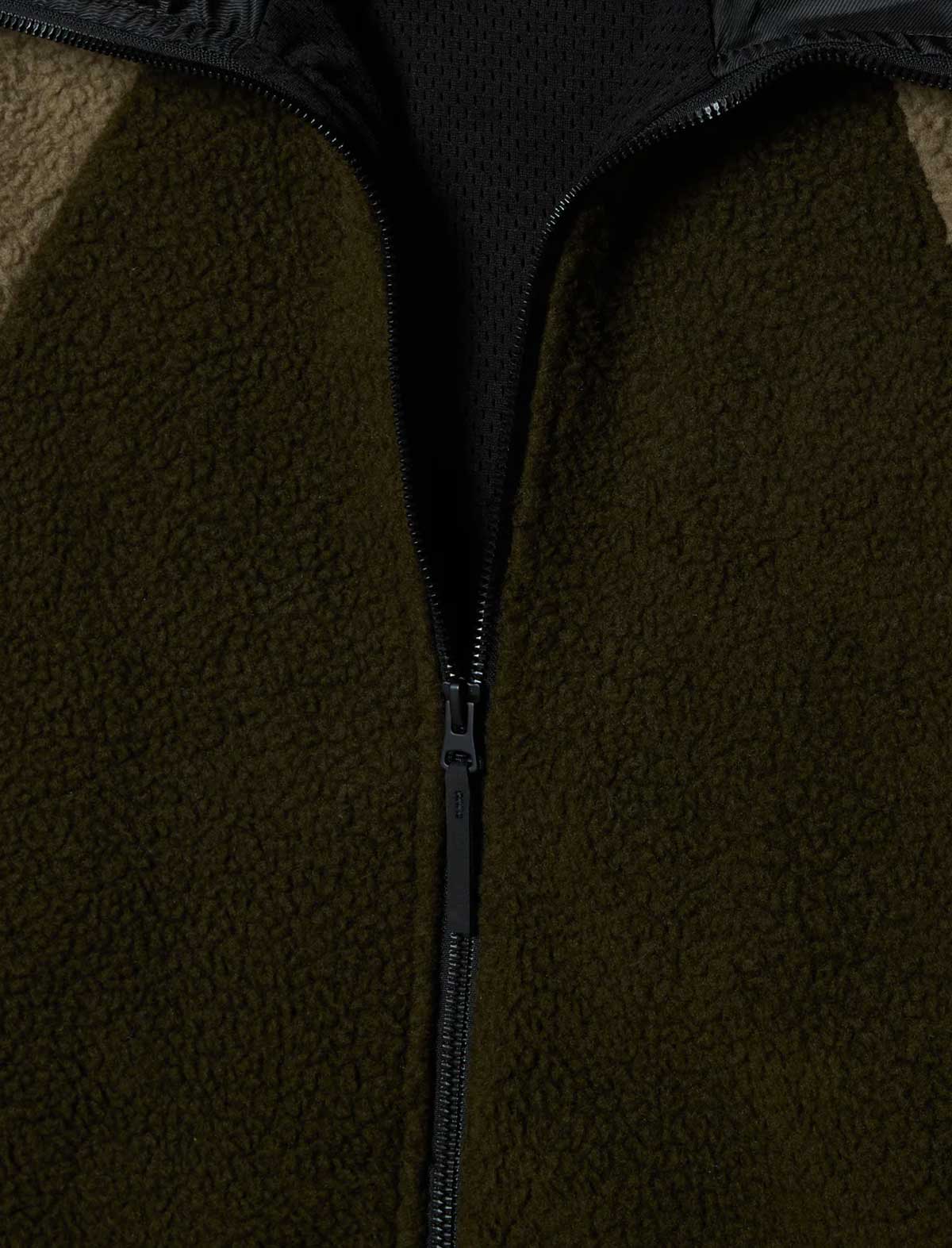 Close-up of a dark green fleece jacket with a zipper