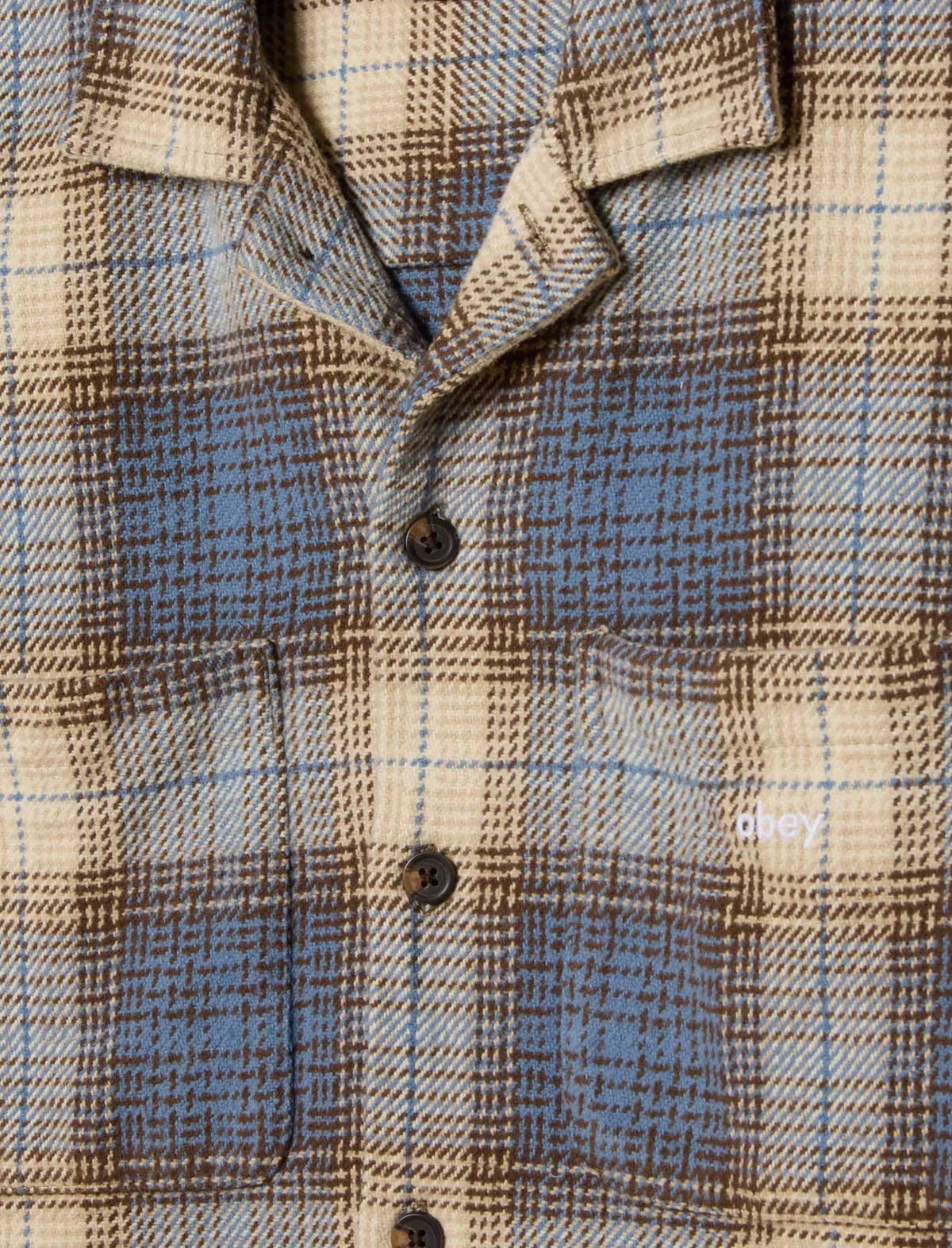 Close-up of a plaid shirt with a focus on the fabric pattern.