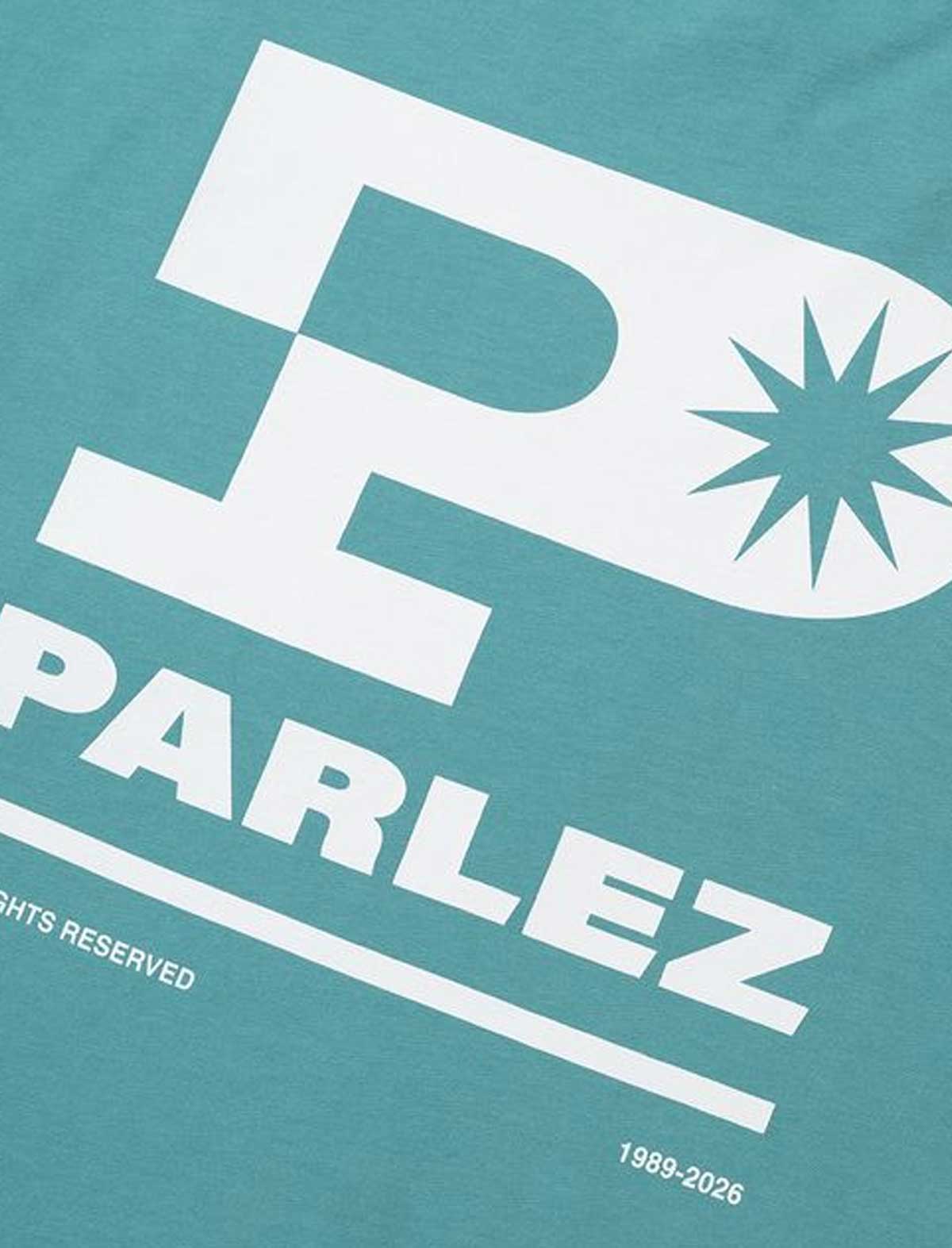 Teal t-shirt with white 'Parlez' logo and design on a teal background
