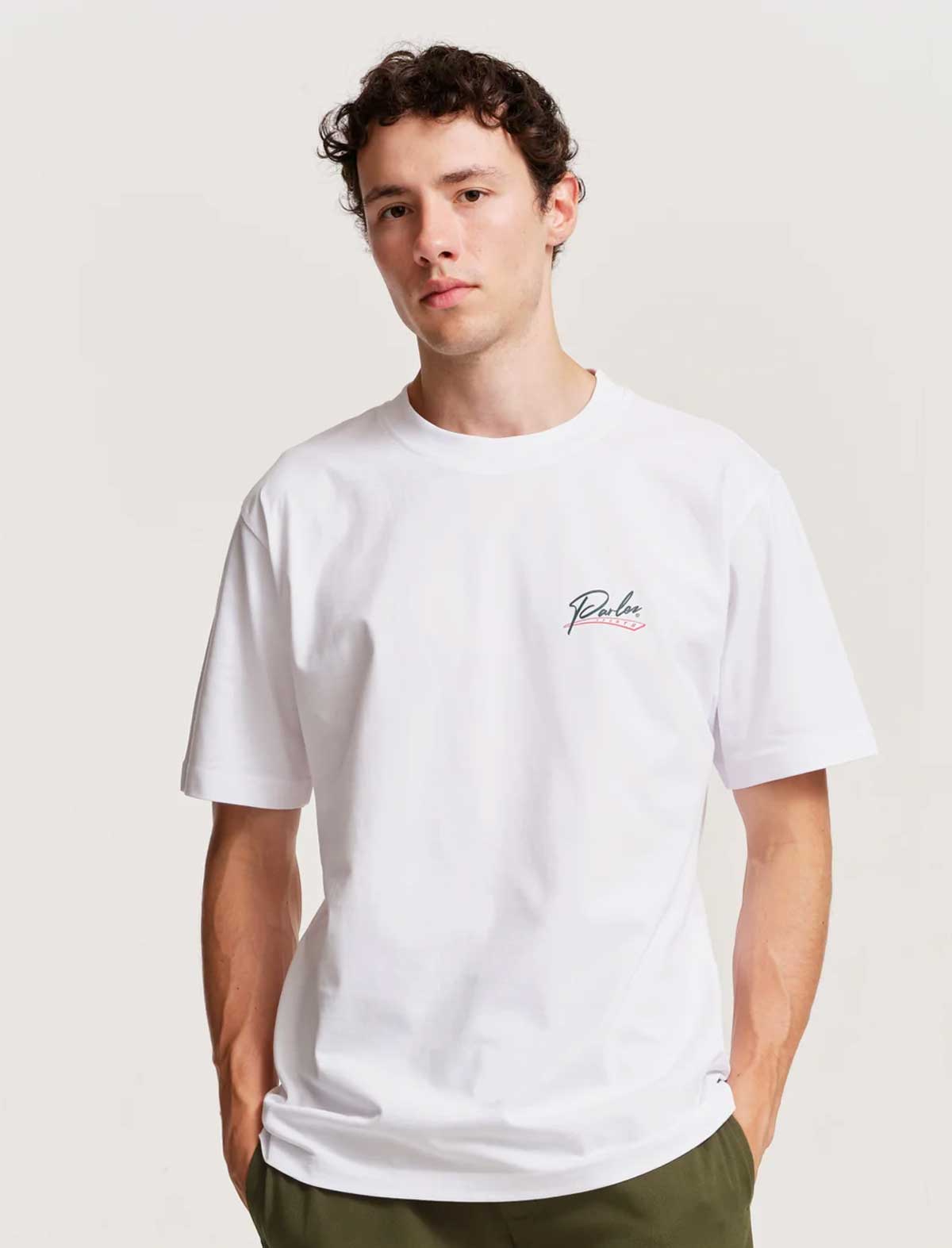 Man wearing a white parlez inning t-shirt with a logo on a plain background