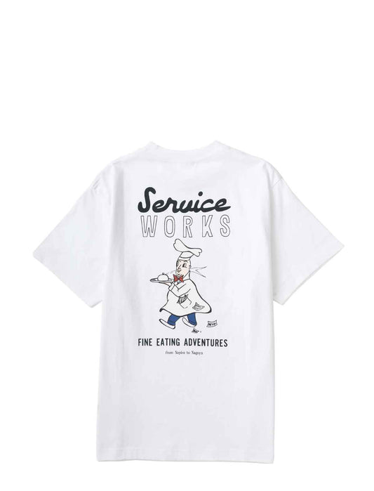 White short-sleeve t-shirt shown from the back, featuring a graphic print of a chef carrying a tray with the text 'Service Works' and 'Fine Eating Adventures'.