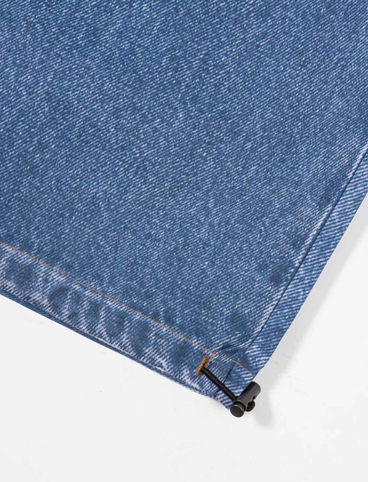 Close-up of blue denim fabric with a zipper on a white background