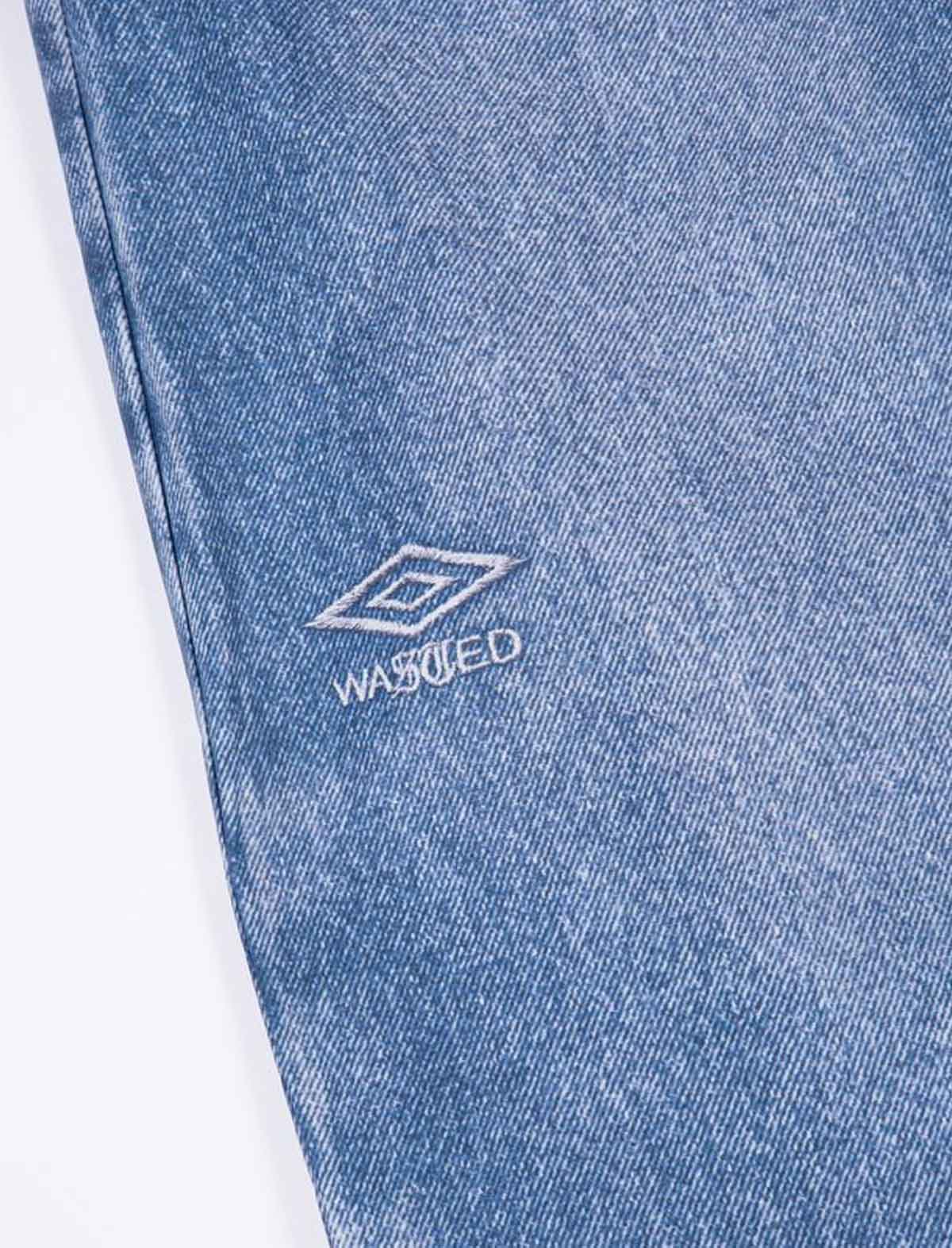 Close-up of blue denim fabric with a brand logo and 'WASHED' text on a white background